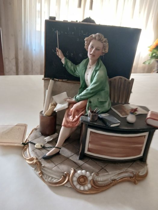 Bela estátua de Capodimonte, representando uma mulher sentada em uma c