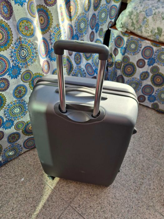 Mala de viagem cinzenta rígida com muito boa capacidade .