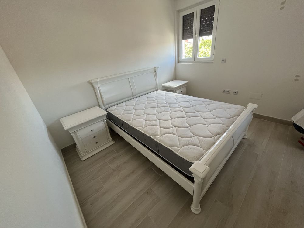 Mesa de cabeceira branca e cama