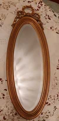 Espelho de parede de talha dourada, esguio ovalado.