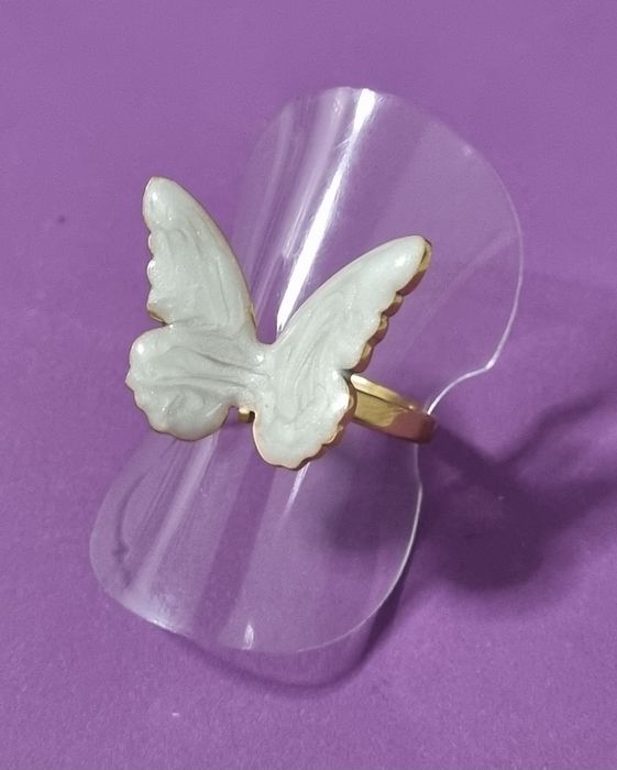 Anel dourado, em açol, com borboleta branca esmaltada. Ajustável