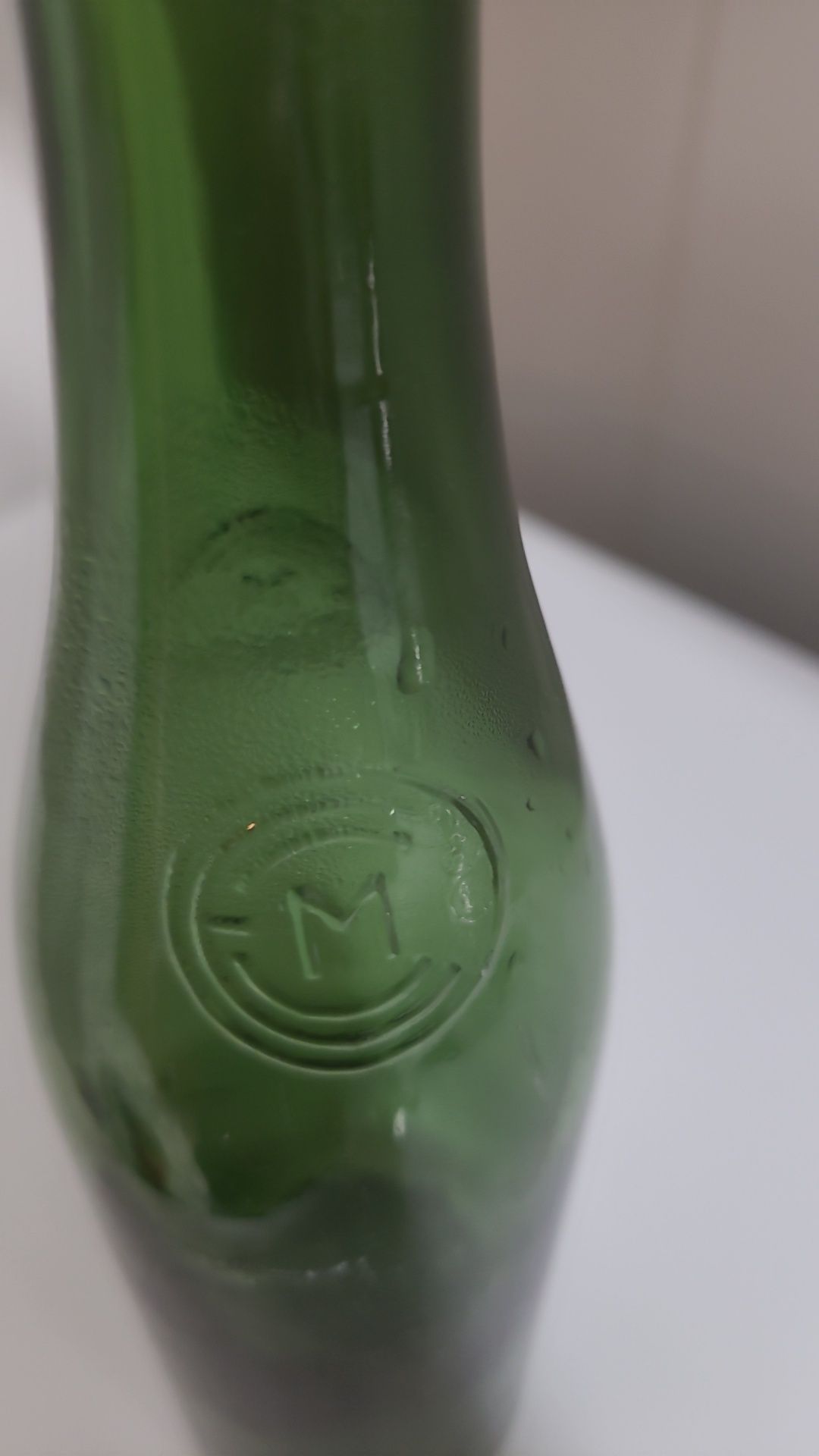 Antiga garrafa de cerveja gravada em alto relevo nas laterais