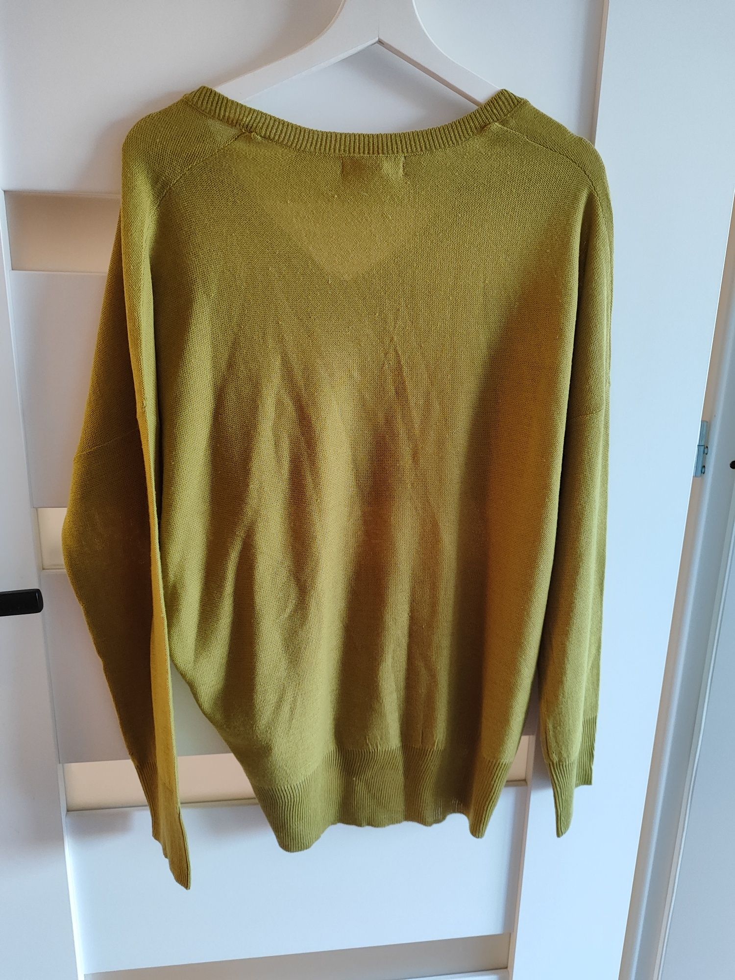 Sweterek oversize w kolorze oliwkowym 
Posiada dekolt w serek. 

Wymia