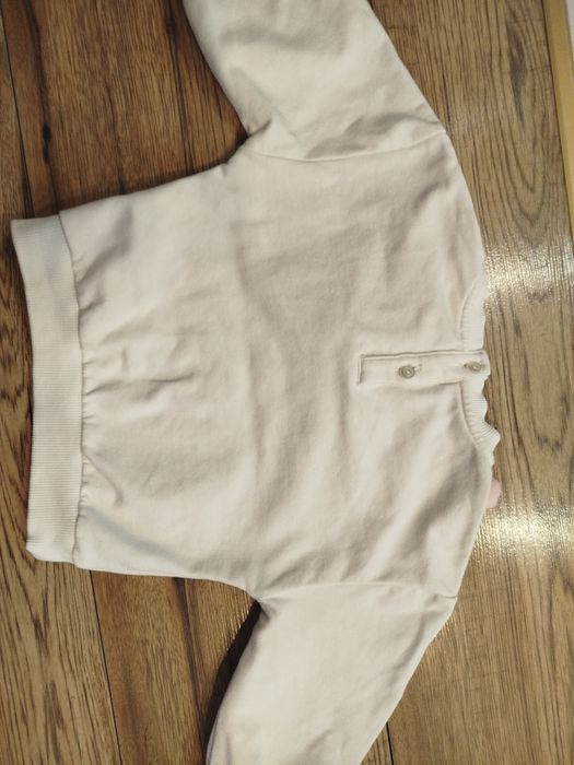 Biała bluza bawełna 80 86 z ozdobną odpinaną dekoracja na dekolcie.