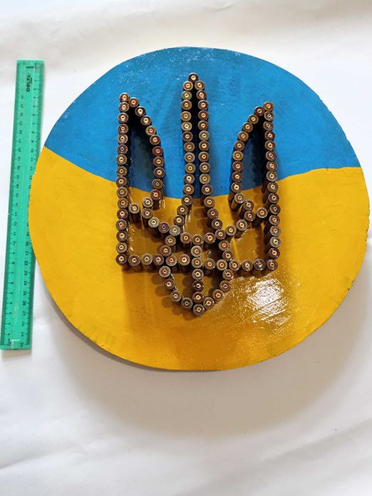 Герб України на зрізі дерева вибиті із стреляних гільз.