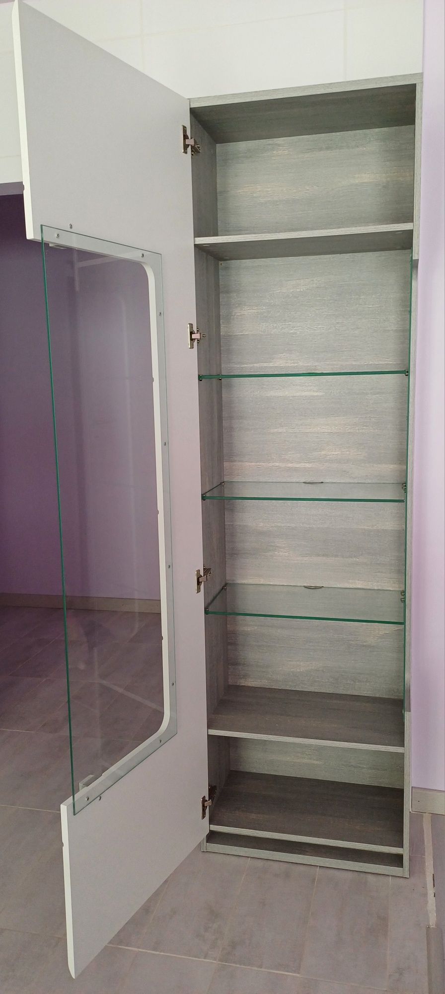 Movel com porta de vidro e prateleiras.