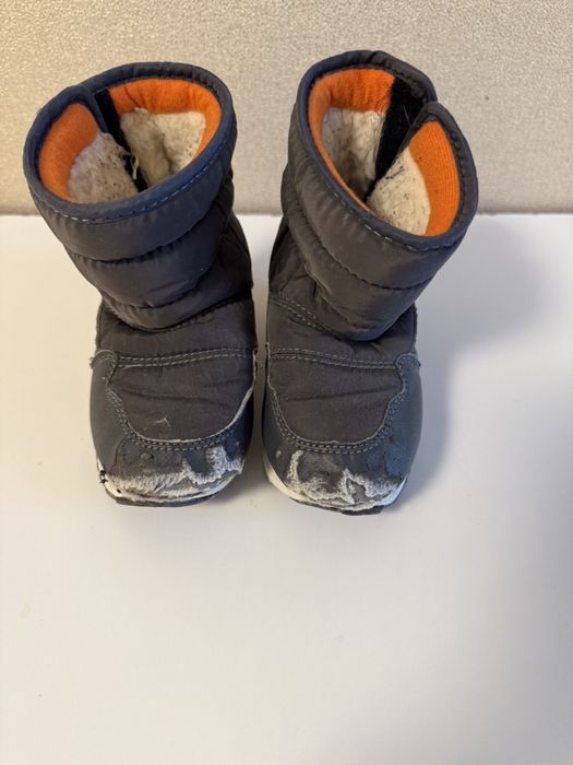 Дитячі зимові сапожки біля дому