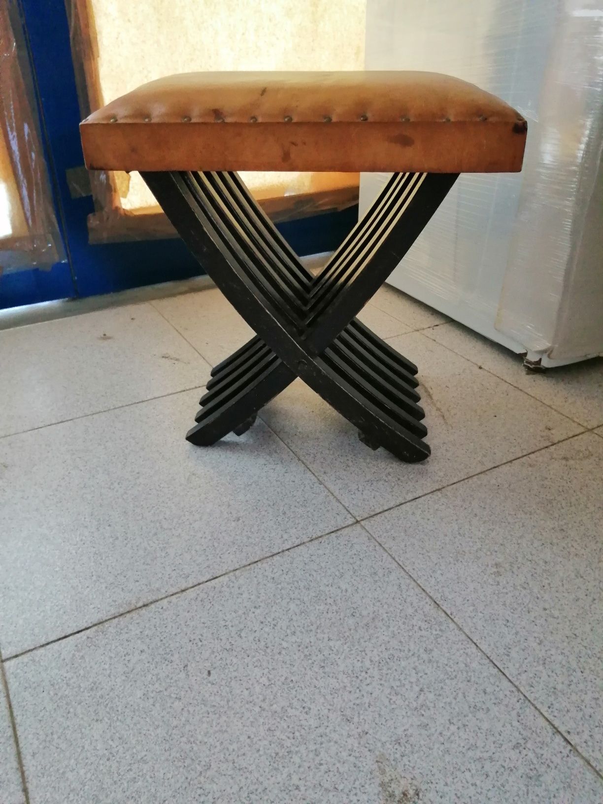 Banco antigo em madeira com estofo de pele.