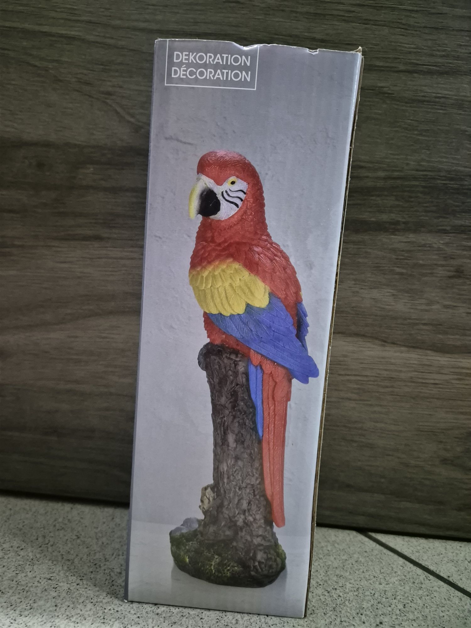 Figurka papugi siedzącej na pniu