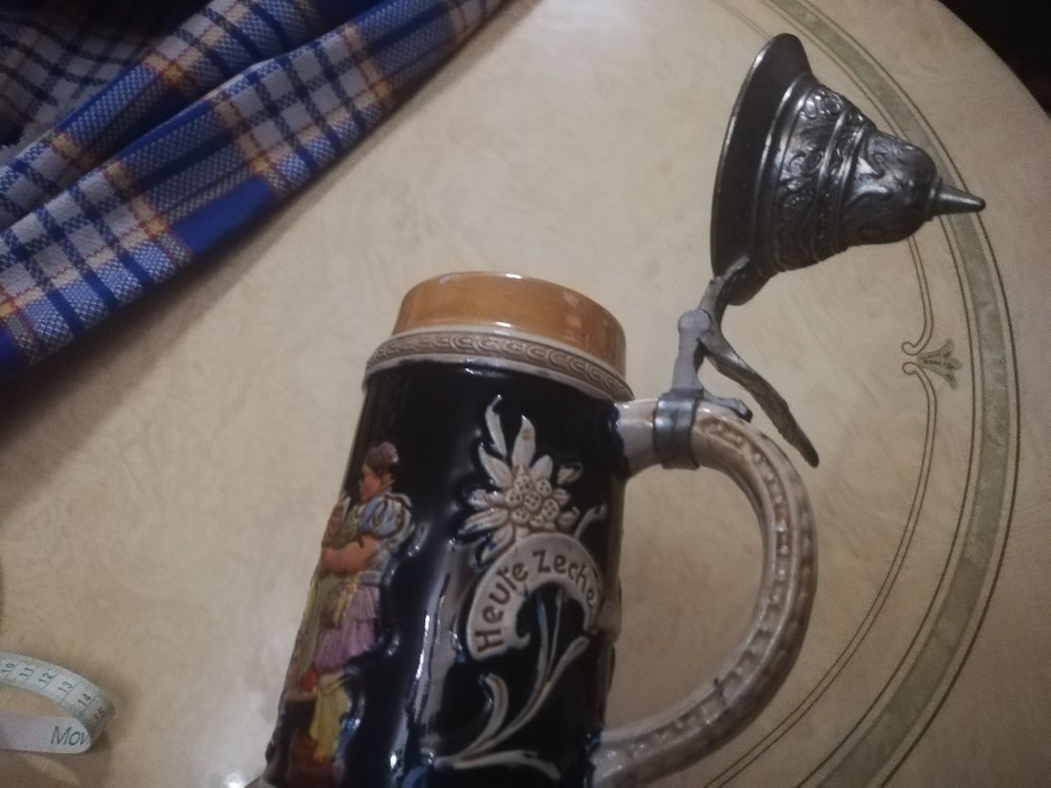 Caneca Alemã antiga com música e figuras em relevo.