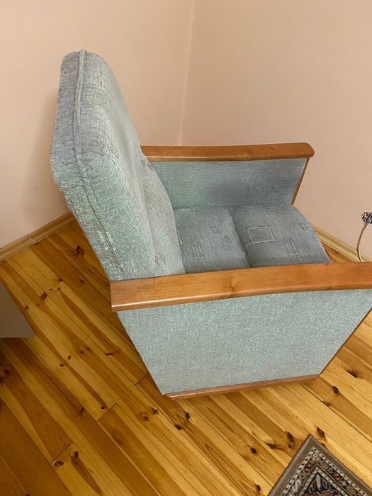 Dwa fotele z solidnej  zielonej tkaniny z drewnianymi podłokietnikami