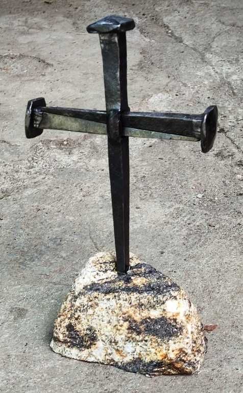 Krzyż z kutych gwoździ na kamiennym postumencie