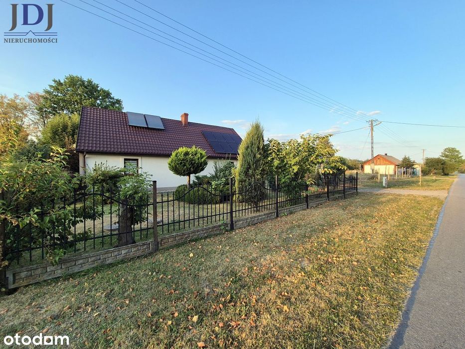 Urokliwy drewniany dom z duszą wśród zieleni.
