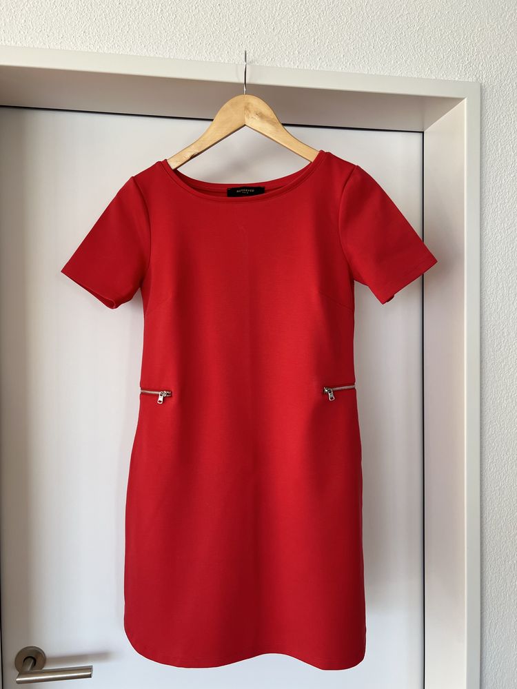 Czerwona sukienka z ozdobnymi zamkami