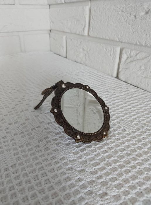 Lusterko z metalowej oprawie.