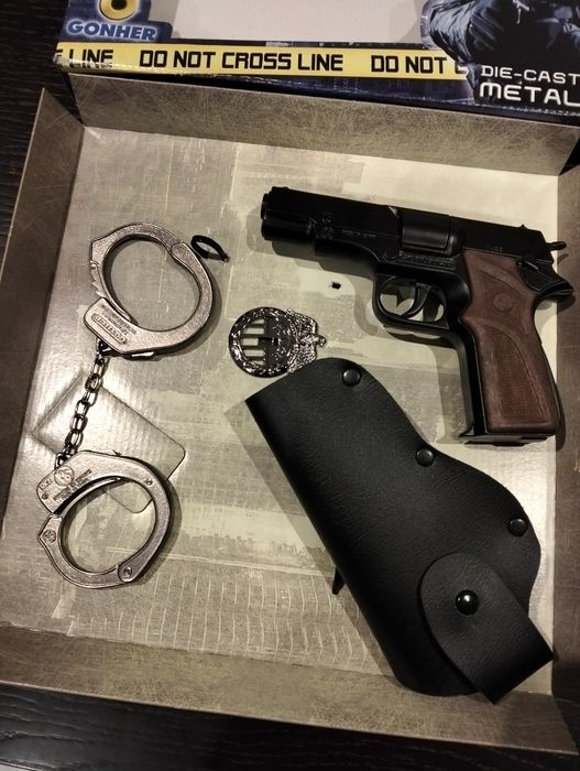 Kit de pistola de fulminantes 
Arma, algemas e distintivo em metal
Col