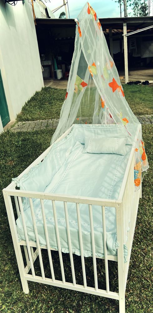 Cama de bebê com colchão e textil em bom estado