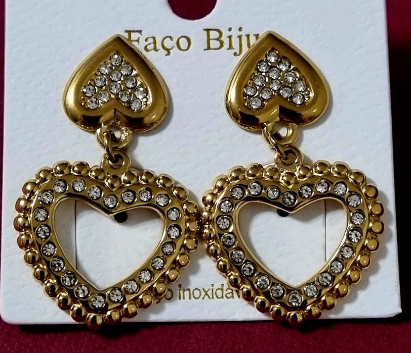 Brincos dourados, em aço, 2 corações invertidos com zirconias. De pico