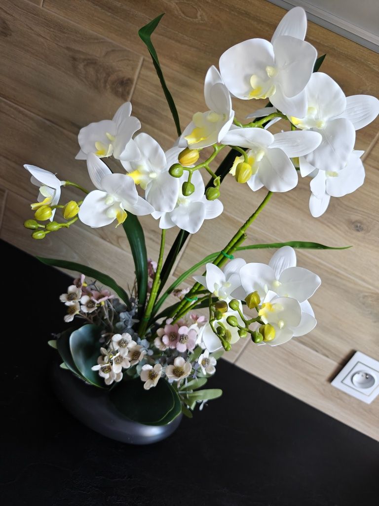 Sztuczny storczyk orchidea w czarnej ceramicznej doniczce