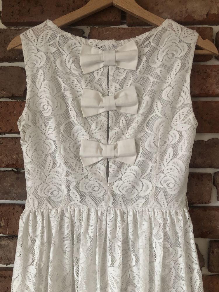 187. r.S biała koronkowa sukienka z kokardkami. Rozkloszowana