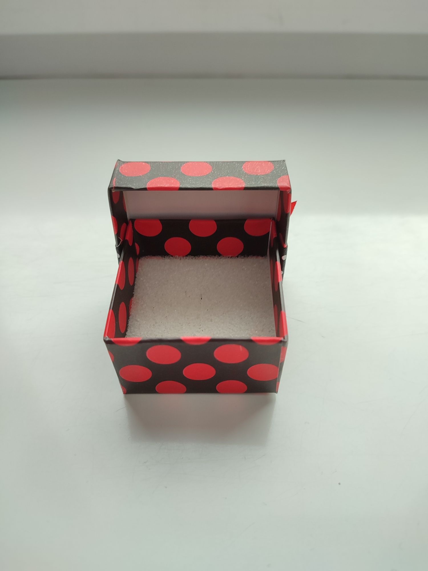 Czarne pudełko z czerownymi kropkami na biżuterię