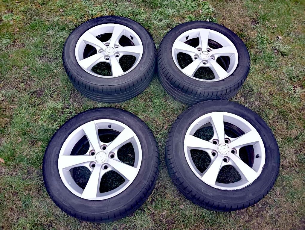 Oryginalne felgi aluminiowe mazda 16" z 2 letnimi oponami DUNLOP