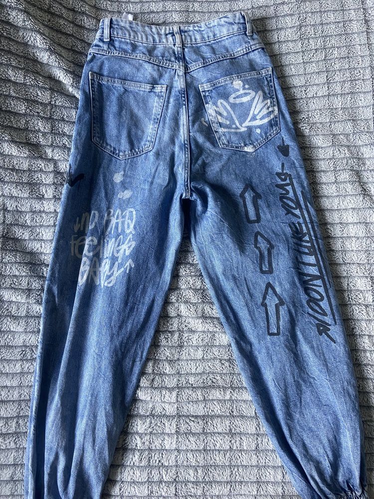 szerokie jeansy ze ściągaczami i napisami