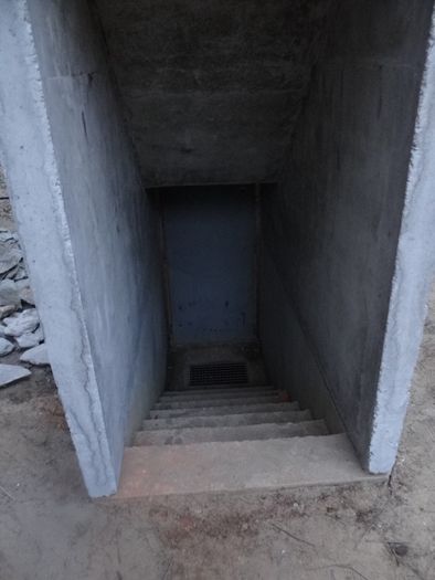 Schody betonowe do piwnicy betonowej kotłowni ze spocznikiem i kratką