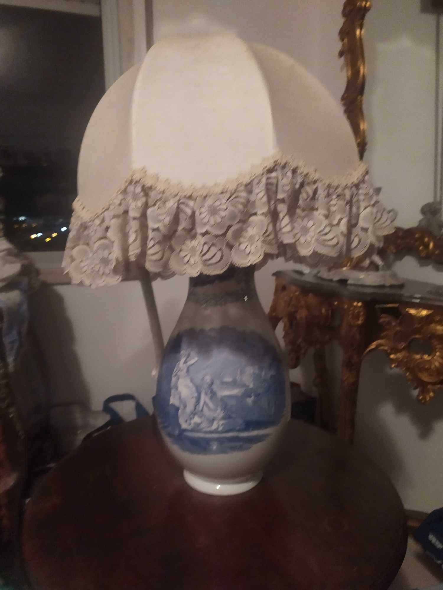 vende-se candeeiro em forma de urna  com motivo mitológico numa mesa