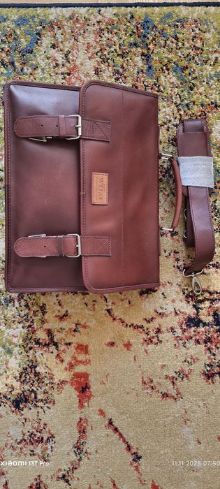 Teczka skórzana z rączką i paskiem na ramię.