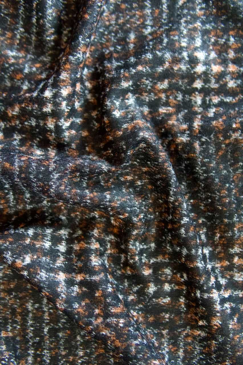 Czarna tkanina tweedowa w biało-pomarańczową kratkę