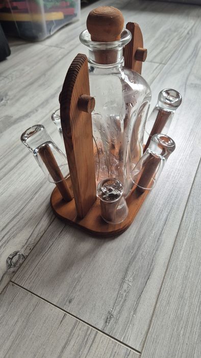 Ozdobna karafka na alkohol na drewnianym stojaku z kieliszkami