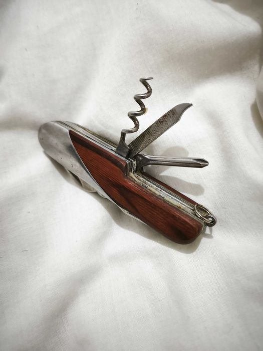 Canivete multifunções com acabamento em madeira e metal.