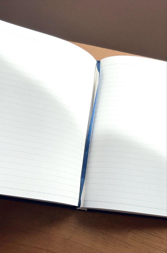 Caderno e capa dura forrada a tecido azul e com linhas