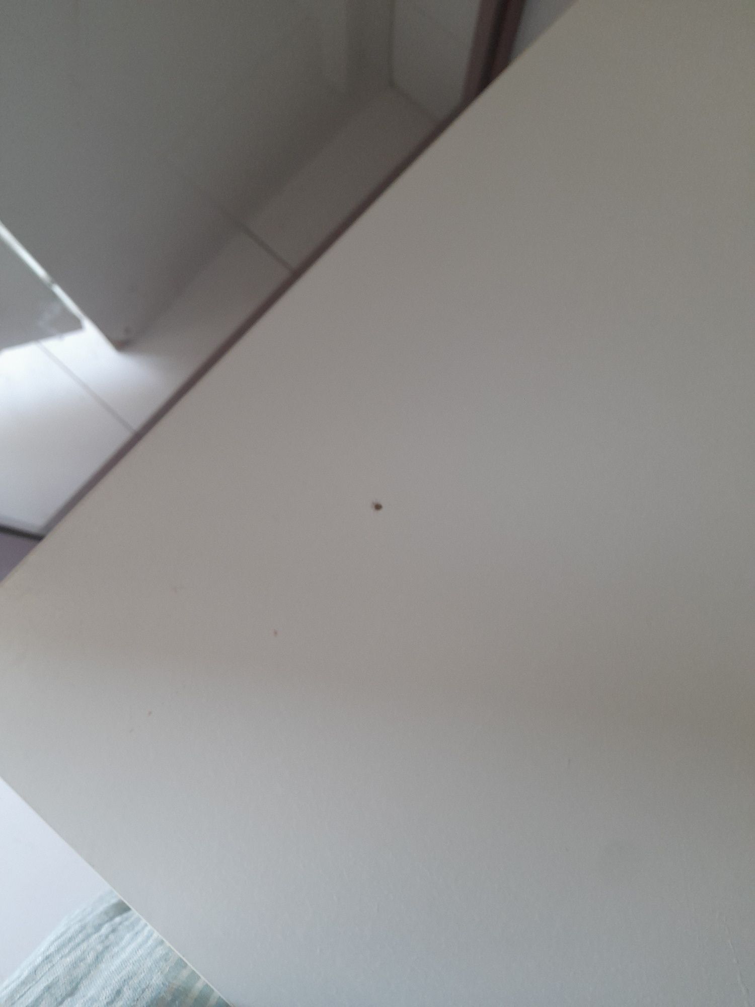 Mesa Ikea com uma pequena marca de uso no tampo.