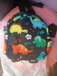 Mini mochila preta com dinossauros para criança