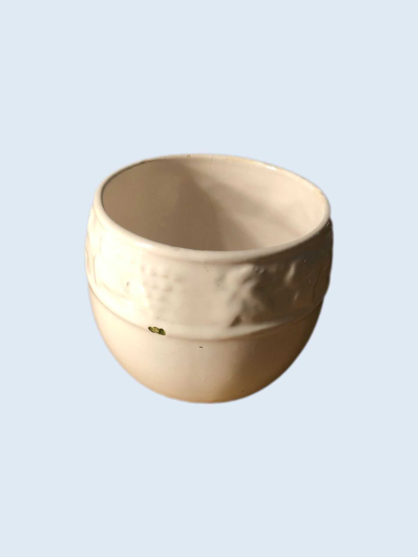 Pequeno pote em cerâmica branco com algumas marcas de uso