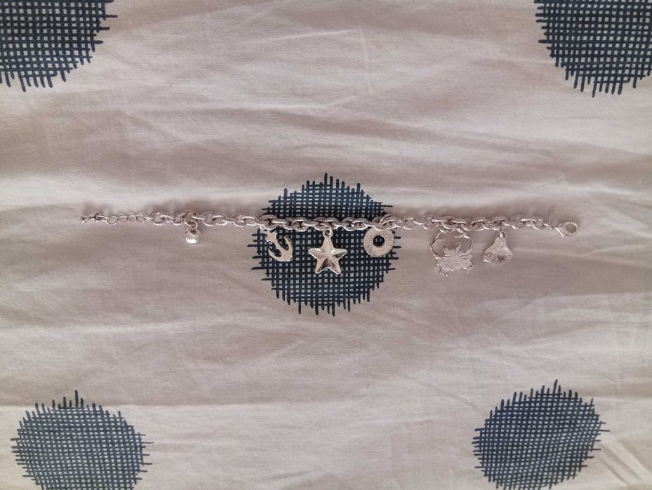 Pulseira nova, em metal prateado, com pendurezas de motivos náuticos