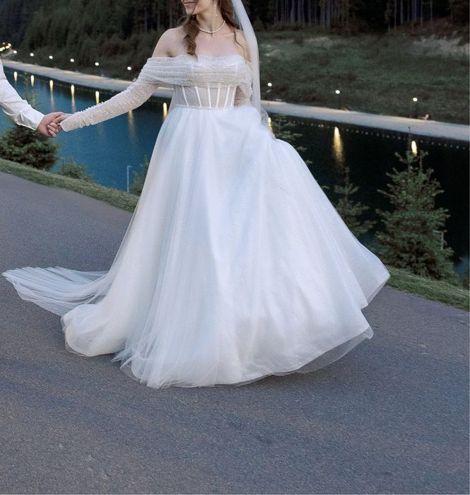 Весільна сукня зі спадаючими на плечі крильцями