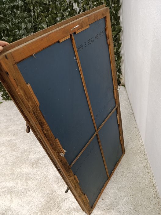 Lustro w starej drewnianej ramie okiennej.