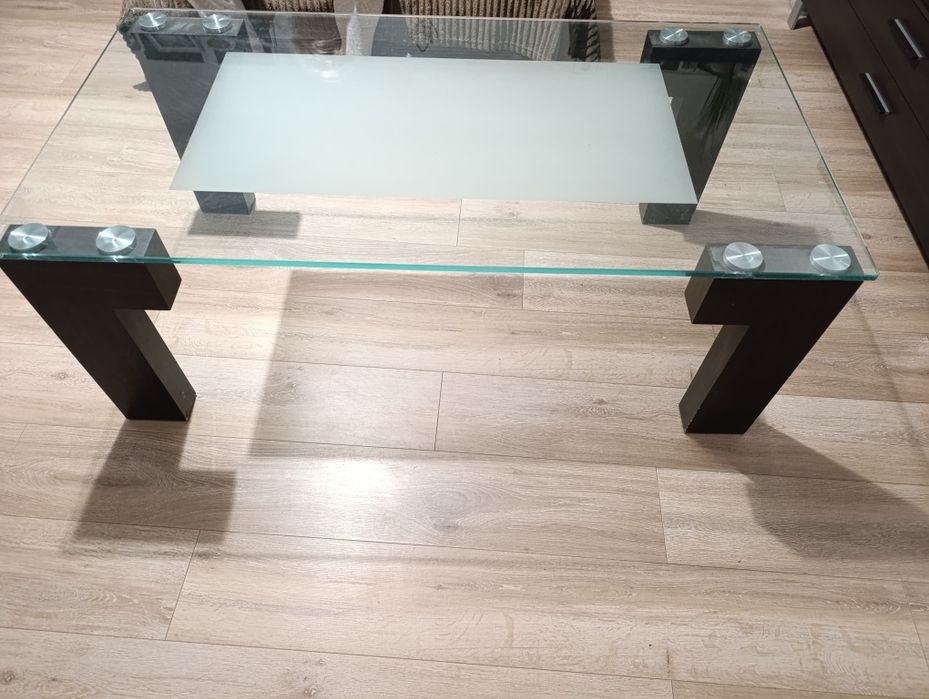 Duży stolik szklany z drewnianymi masywnymi nogami