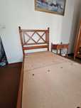 Uma cama de solteiro (2 por 1 metro) e uma mesa de cabeceira.