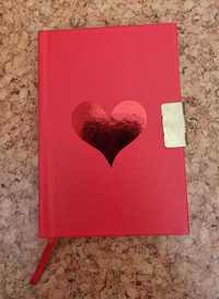 Caderno vermelho pequeno com um coração