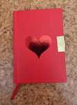 Caderno vermelho pequeno com um coração