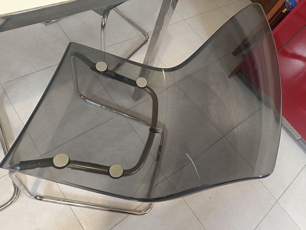 Mesa de vidro com estrutura metálica + 4 cadeiras acrílicas cinzentas