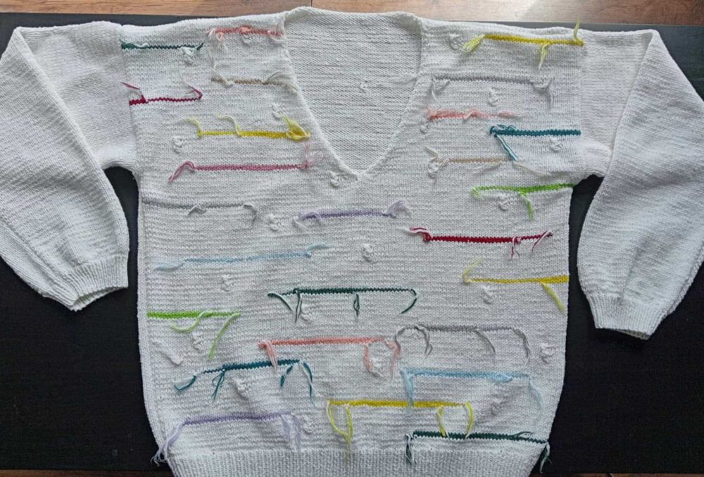 Ręcznie robiony sweter z kolorową abstrakcją na tle bieli