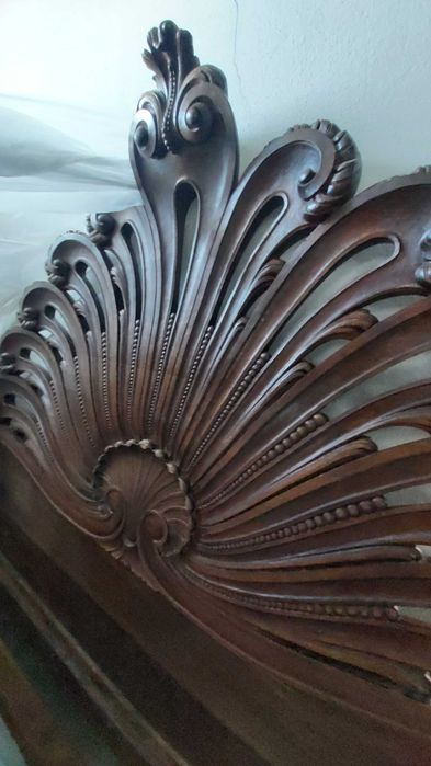 Cama casal de madeira maciça talhada com estrutura e cabecera.