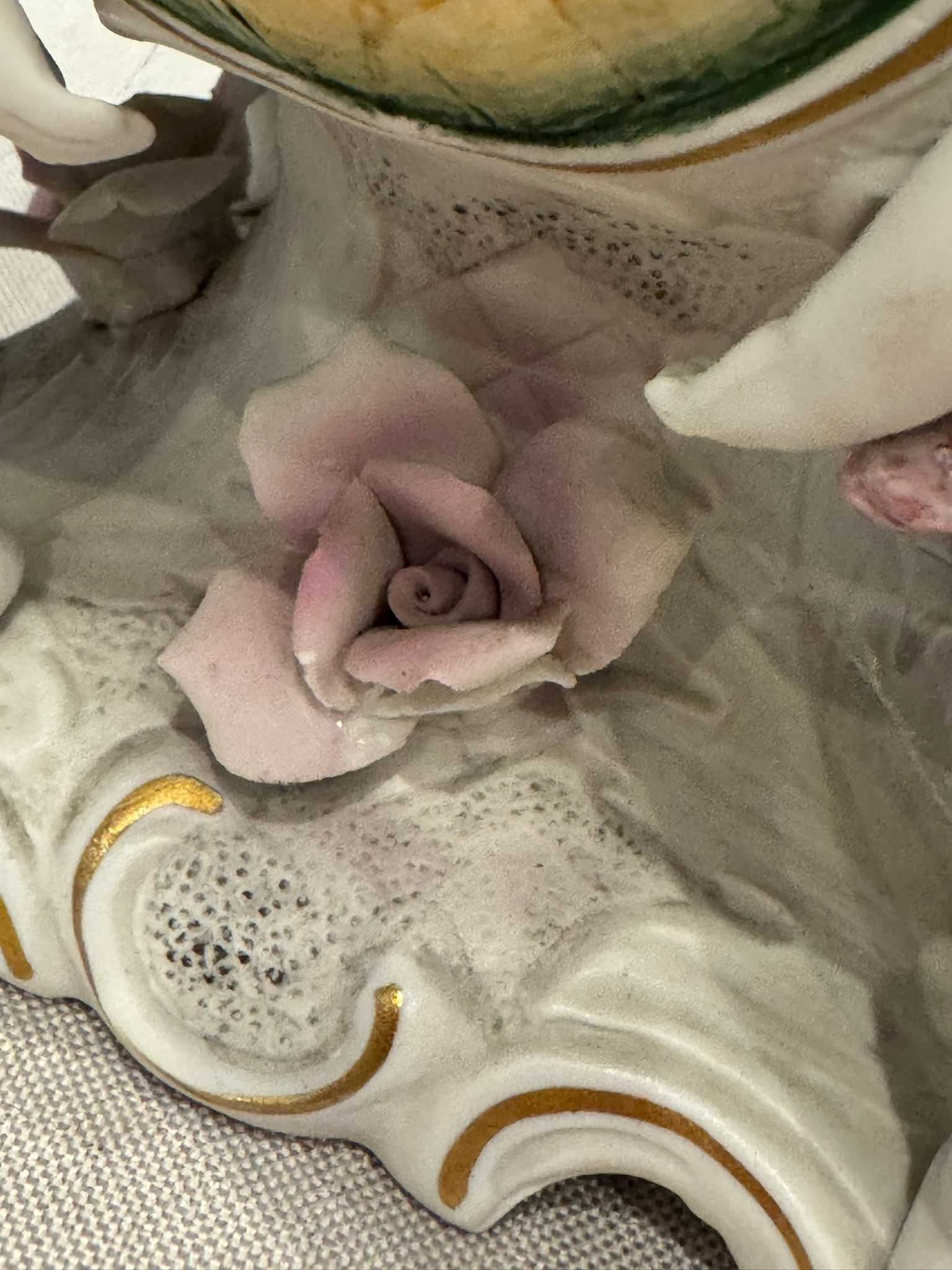 Misa (żardiniera) trzymana przez Putto, porcelana ręcznie malowana.