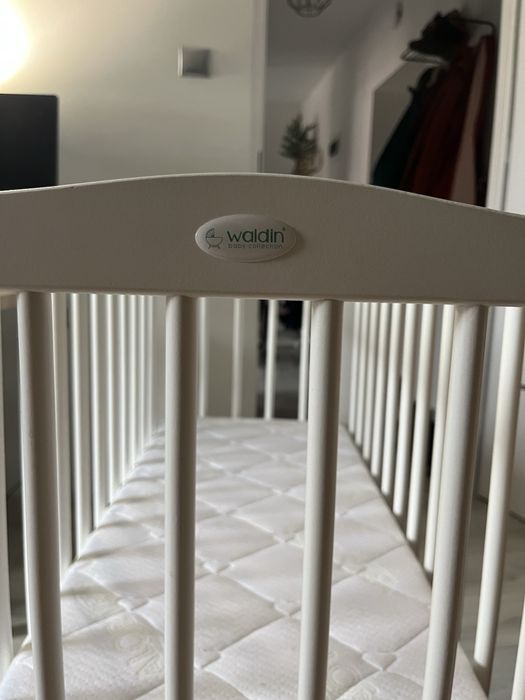 Małe łóżeczko dziecięce niemowlęce drewniane na kółkach z materacem