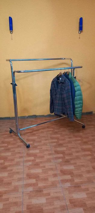 Хромована стійка-вішалка для одягу на колесах.